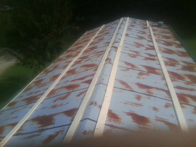 Rusted metal roof panels with new wood purlins before replacement — Storm Damage Roof Repair in Adel by Roofing Brothers