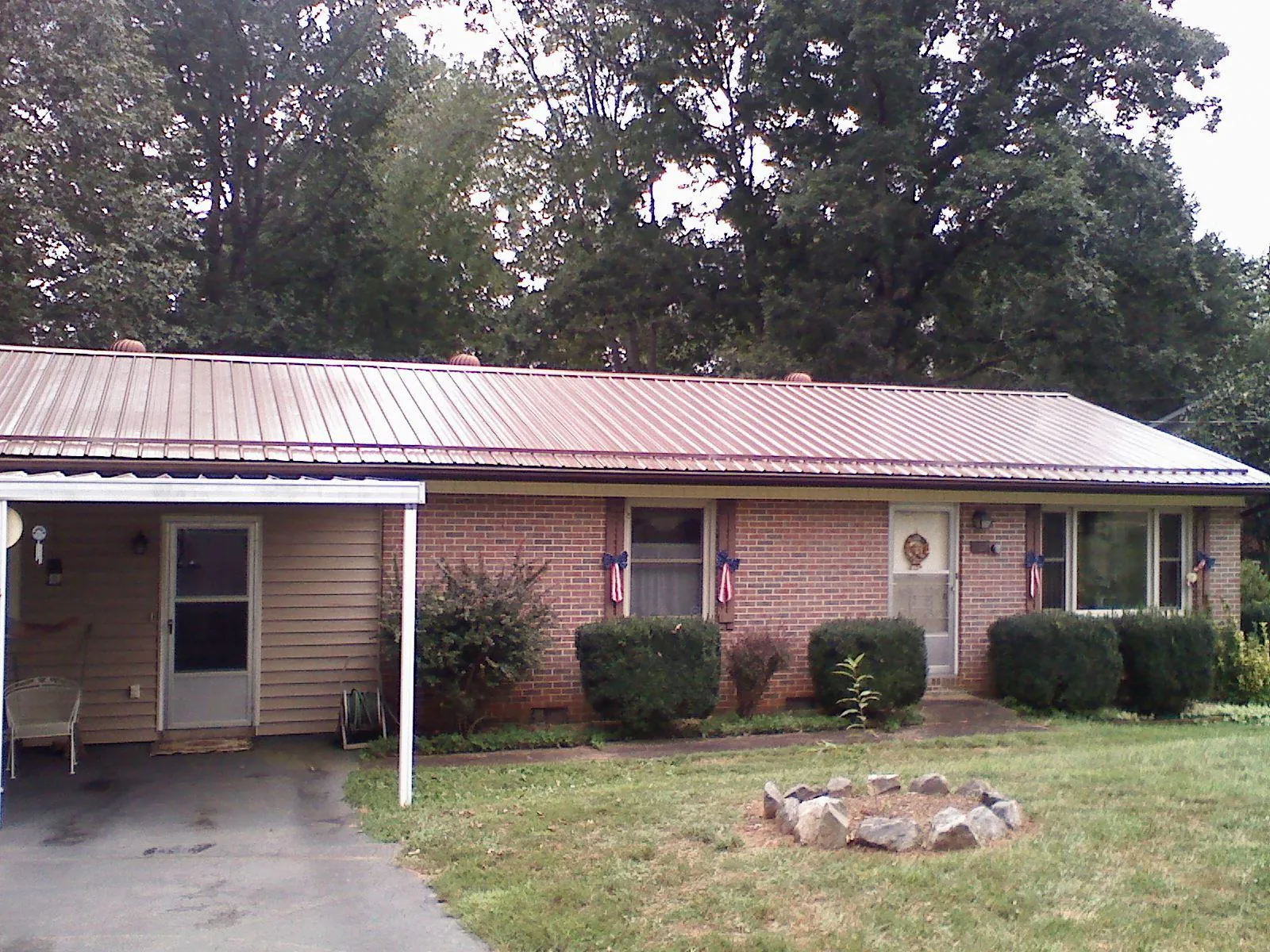 Bronze metal roof and carport on a brick ranch home — Roof Repair work by our crew in Adel